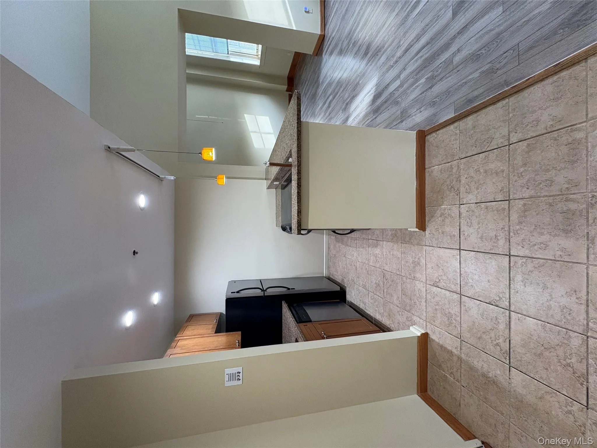 Kitchen with dark stone counters, pendant lighting, dishwasher, open floor plan, and recessed lighting Kitchen with dark stone counters, pendant lighting, dishwasher, open floor plan, and recessed lighting