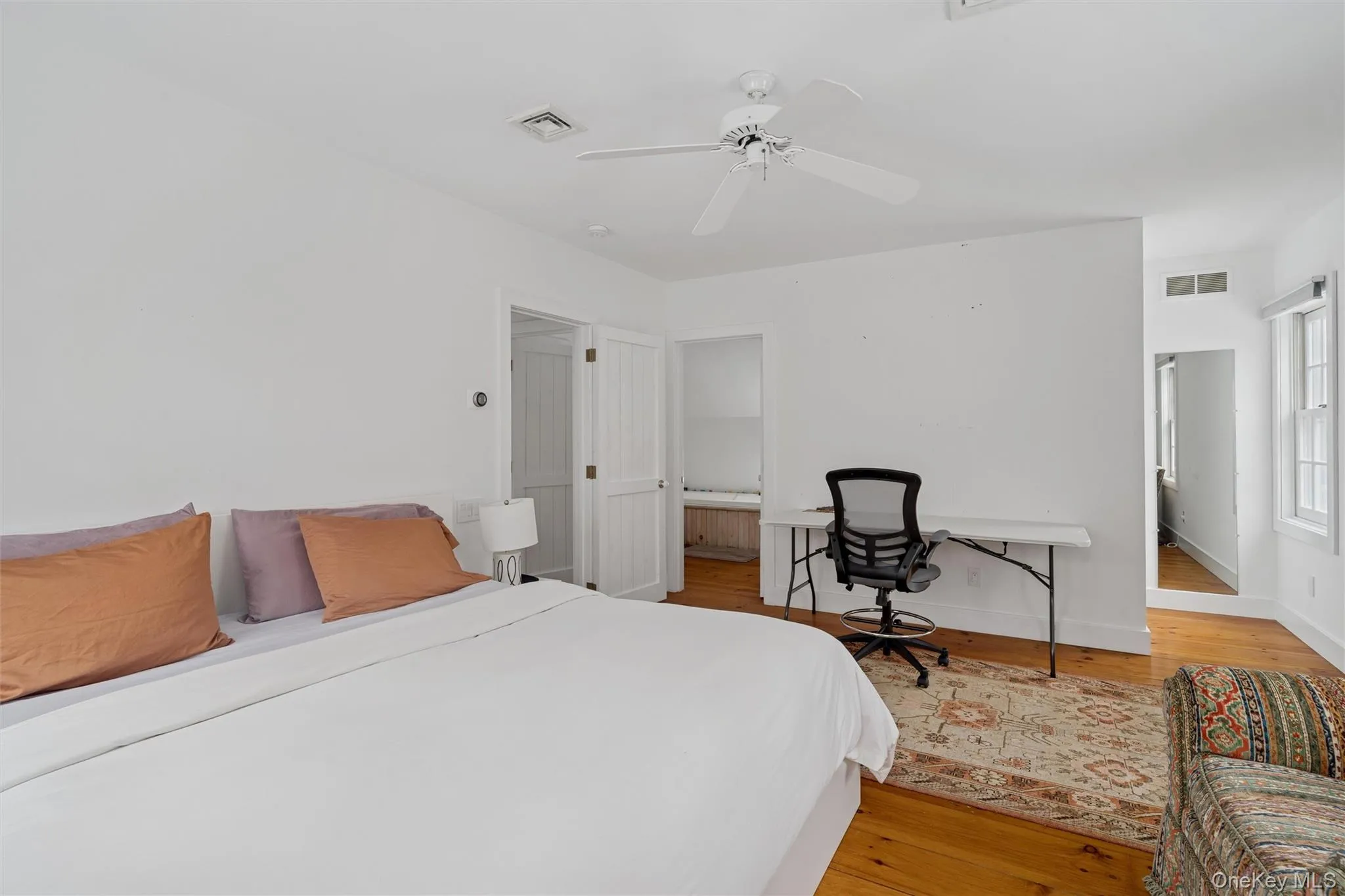 Bedroom featuring light wood finished floors, a desk, and ceiling fan Bedroom featuring light wood finished floors, a desk, and ceiling fan