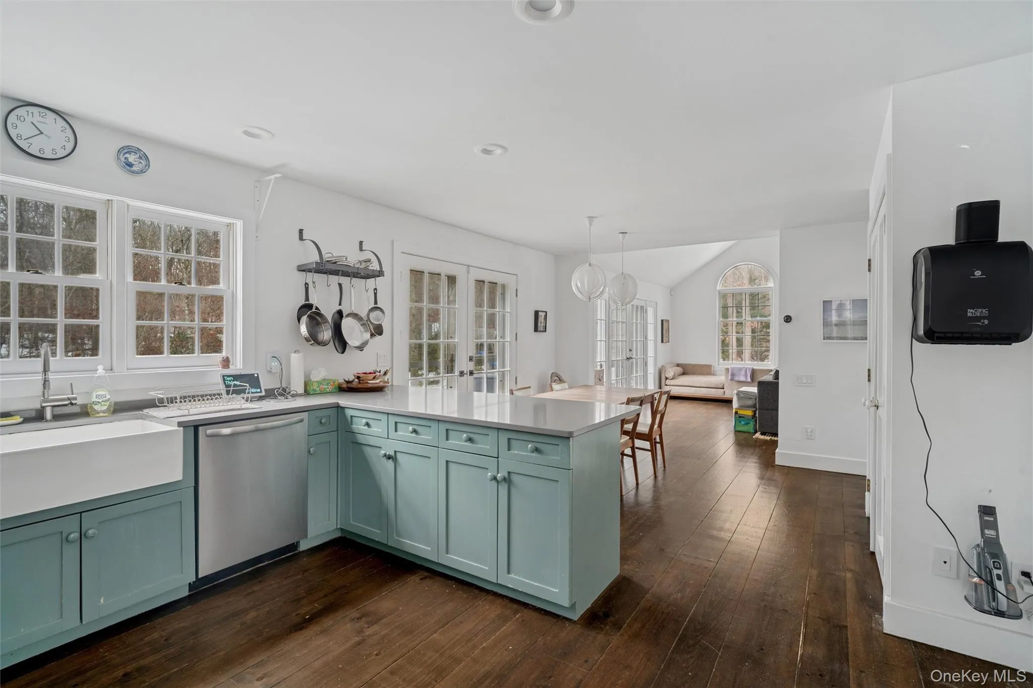 Kitchen featuring a peninsula, stainless steel dishwasher, hanging light fixtures, and light stone countertops Kitchen featuring a peninsula, stainless steel dishwasher, hanging light fixtures, and light stone countertops