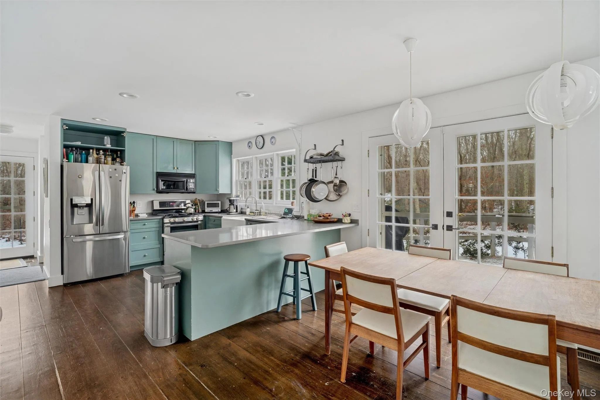 Kitchen featuring open shelves, stainless steel appliances, green cabinets, french doors, and a peninsula Kitchen featuring open shelves, stainless steel appliances, green cabinets, french doors, and a peninsula