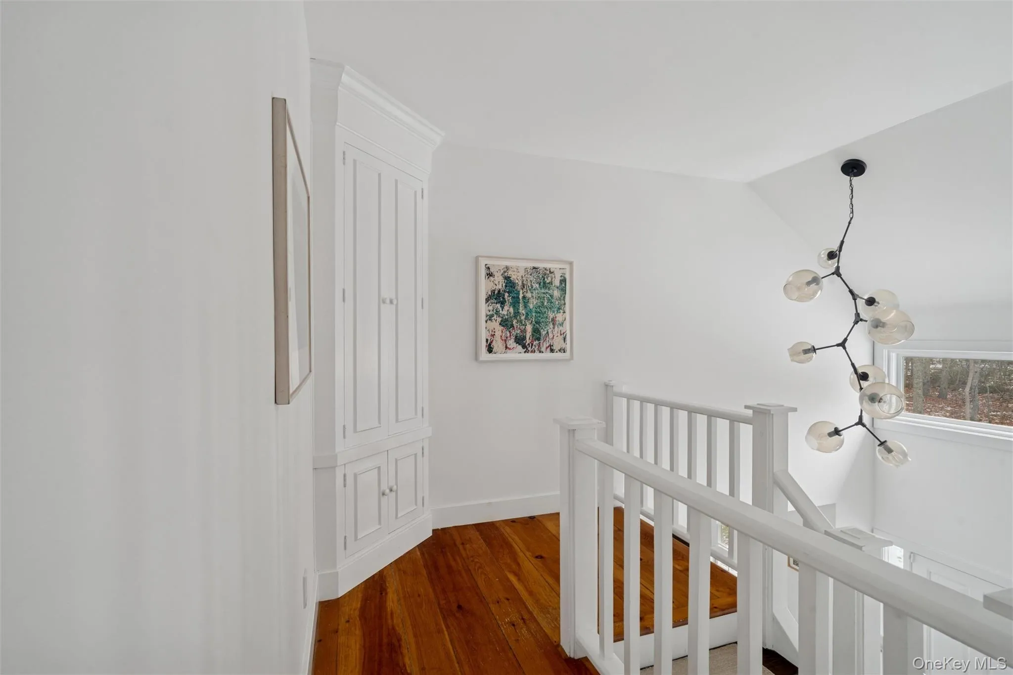 Corridor with an upstairs landing, hardwood / wood-style flooring, and vaulted ceiling Corridor with an upstairs landing, hardwood / wood-style flooring, and vaulted ceiling