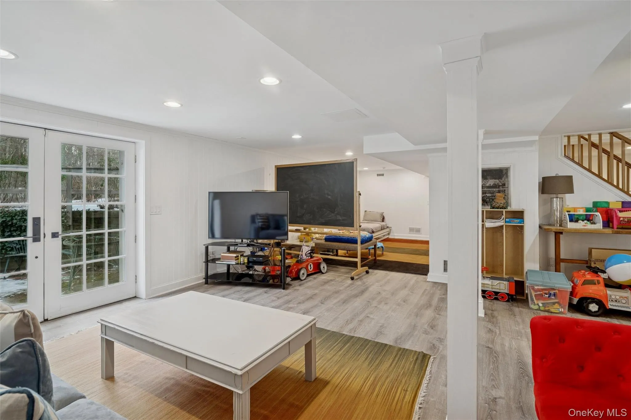 Living area with wood finished floors, stairway, french doors, recessed lighting, and crown molding Living area with wood finished floors, stairway, french doors, recessed lighting, and crown molding
