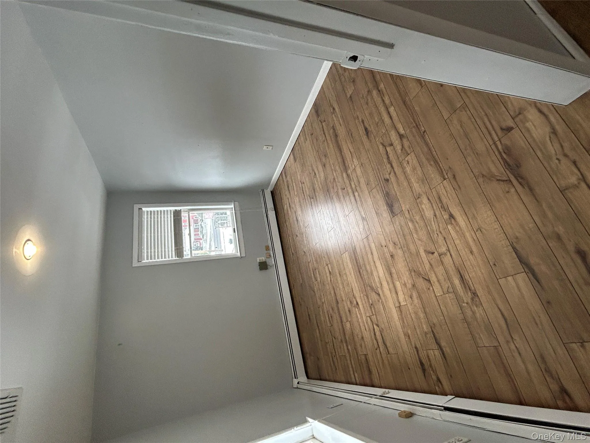 Spare room featuring a baseboard heating unit and hardwood / wood-style floors Spare room featuring a baseboard heating unit and hardwood / wood-style floors