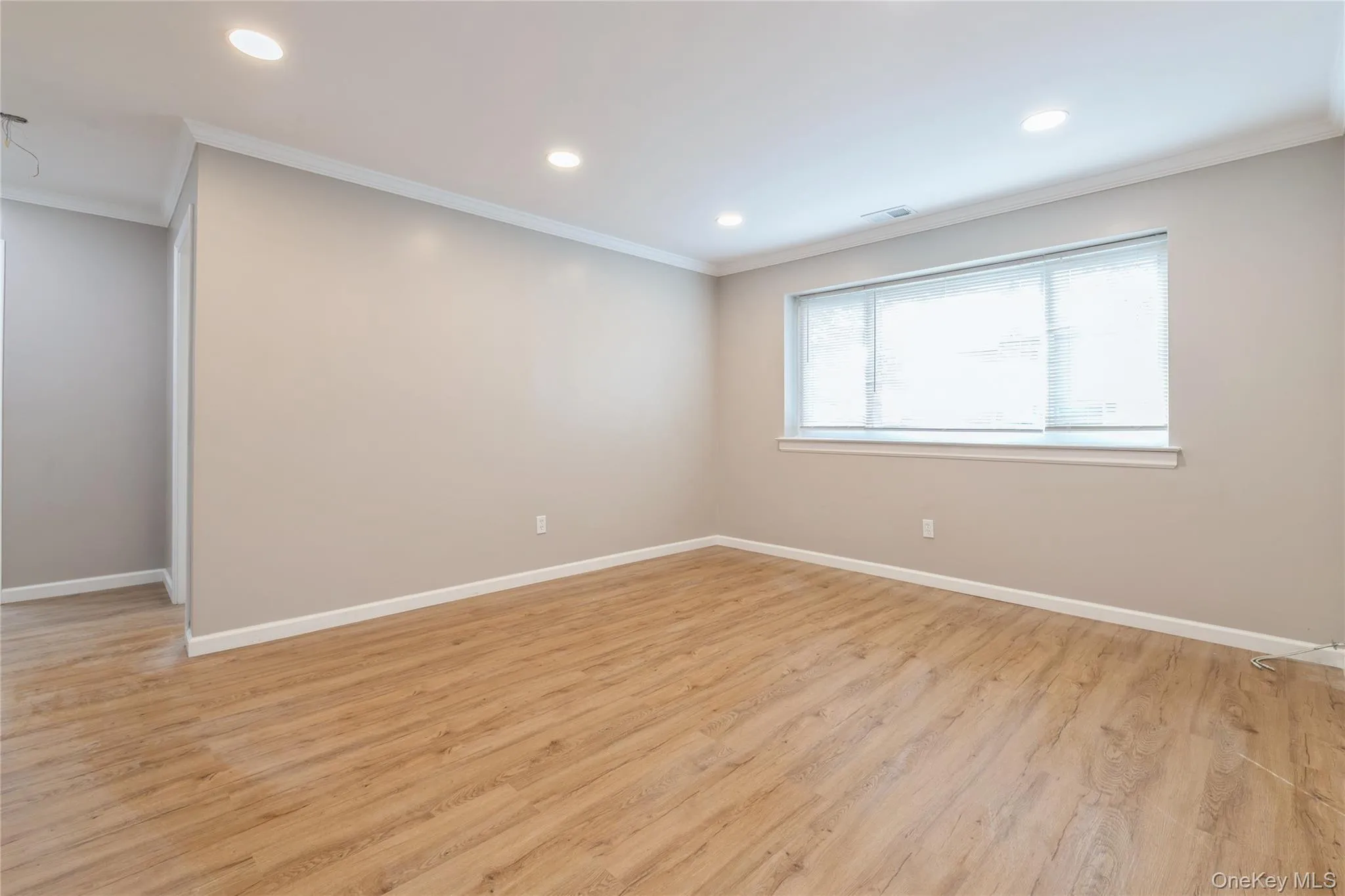 Unfurnished room featuring crown molding, light wood-style flooring, and recessed lighting Unfurnished room featuring crown molding, light wood-style flooring, and recessed lighting
