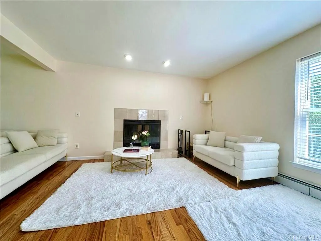 Living room with wood finished floors and a tiled fireplace Living room with wood finished floors and a tiled fireplace