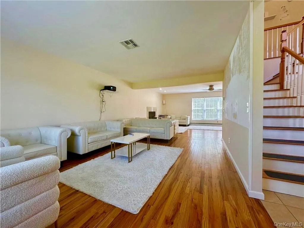 Living area featuring stairs and light wood-style floors Living area featuring stairs and light wood-style floors