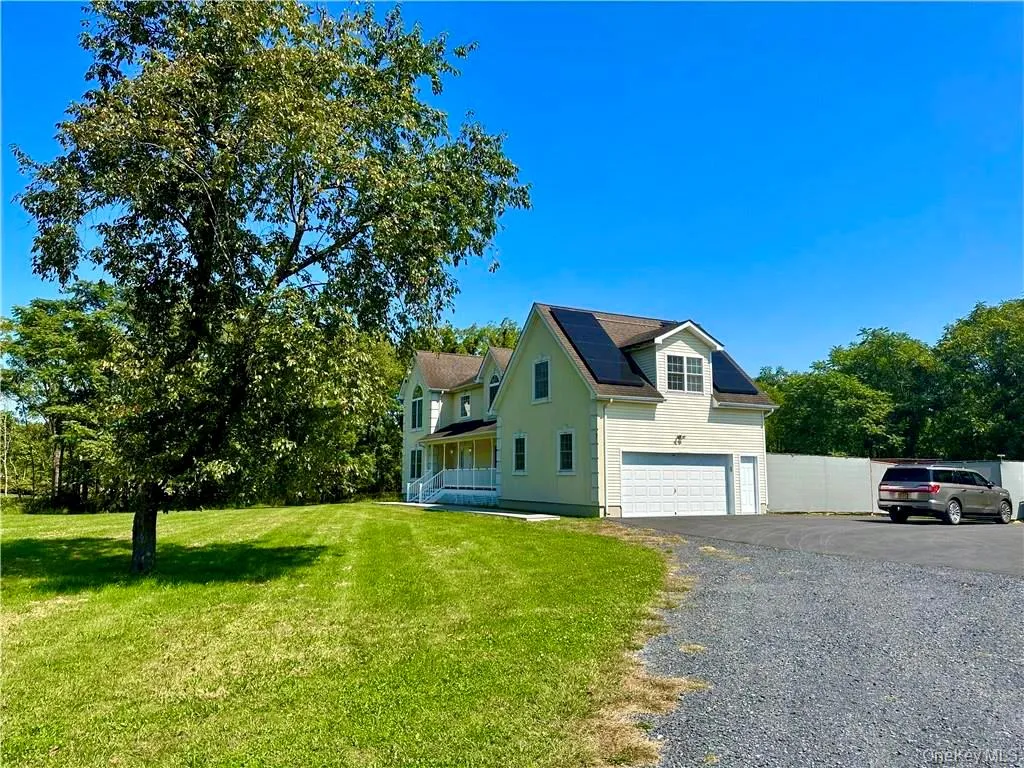 View of property exterior with roof mounted solar panels, driveway, a garage, and a porch View of property exterior with roof mounted solar panels, driveway, a garage, and a porch