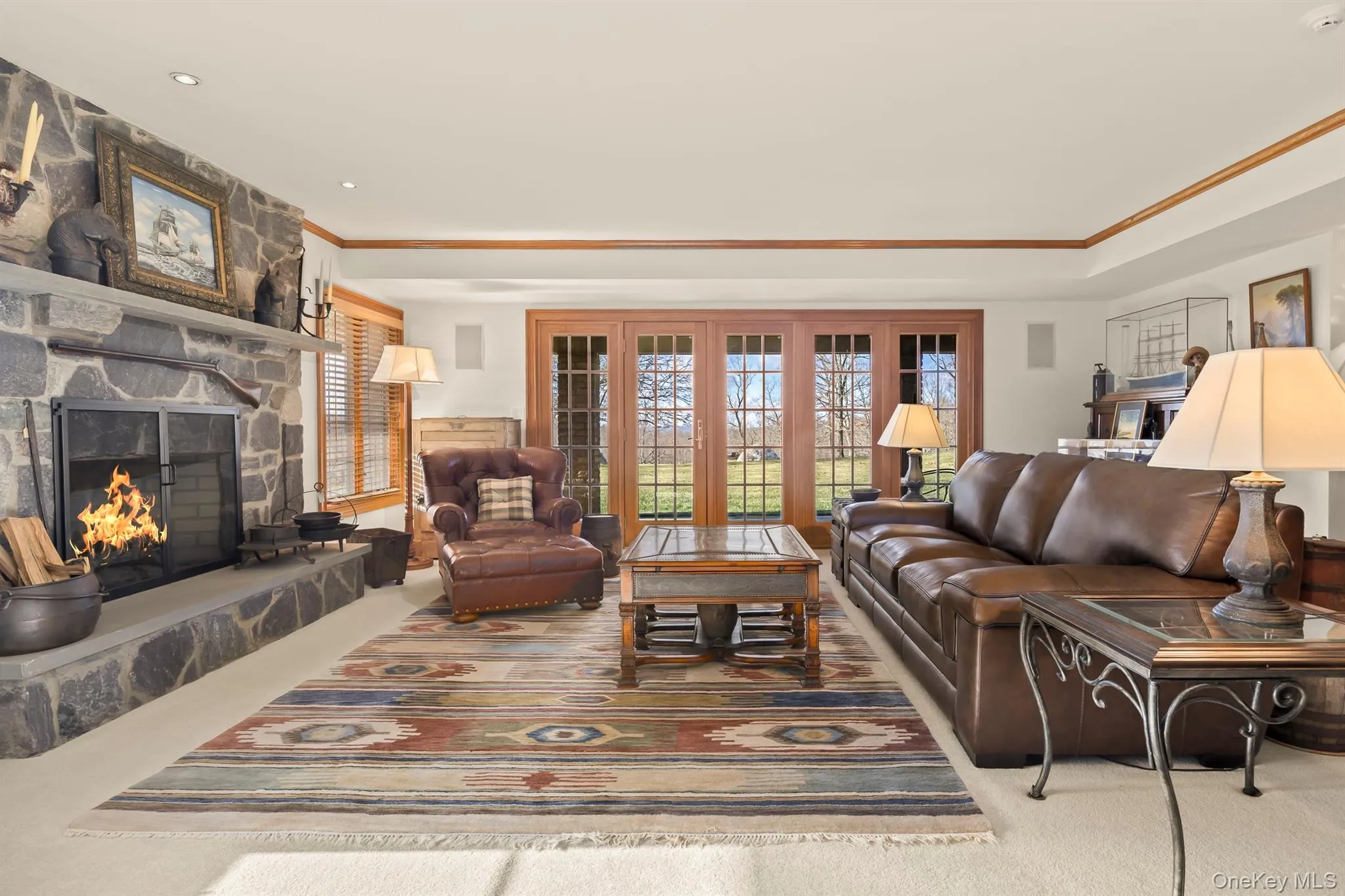 Lower level living room with stone FP and doors to covered patio Lower level living room with stone FP and doors to covered patio