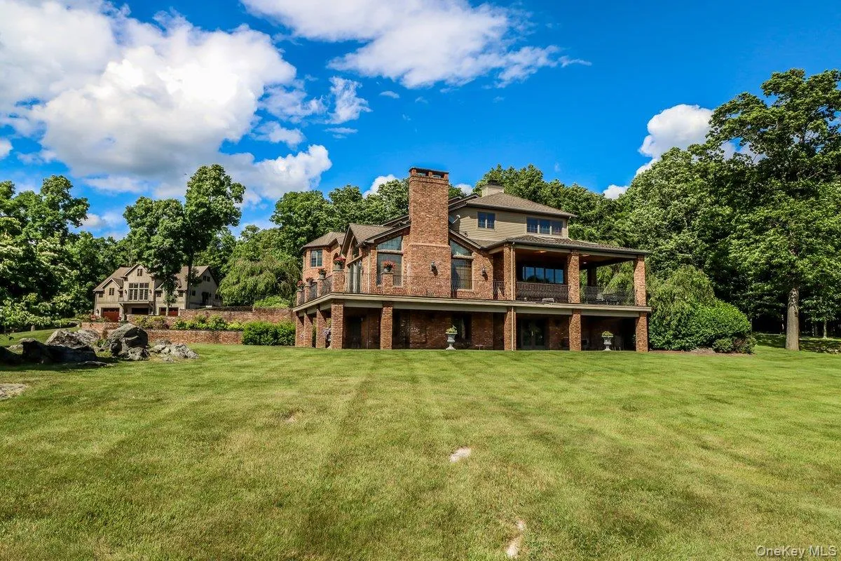Side of house with covered porch and patio, carriage barn in distance Side of house with covered porch and patio, carriage barn in distance