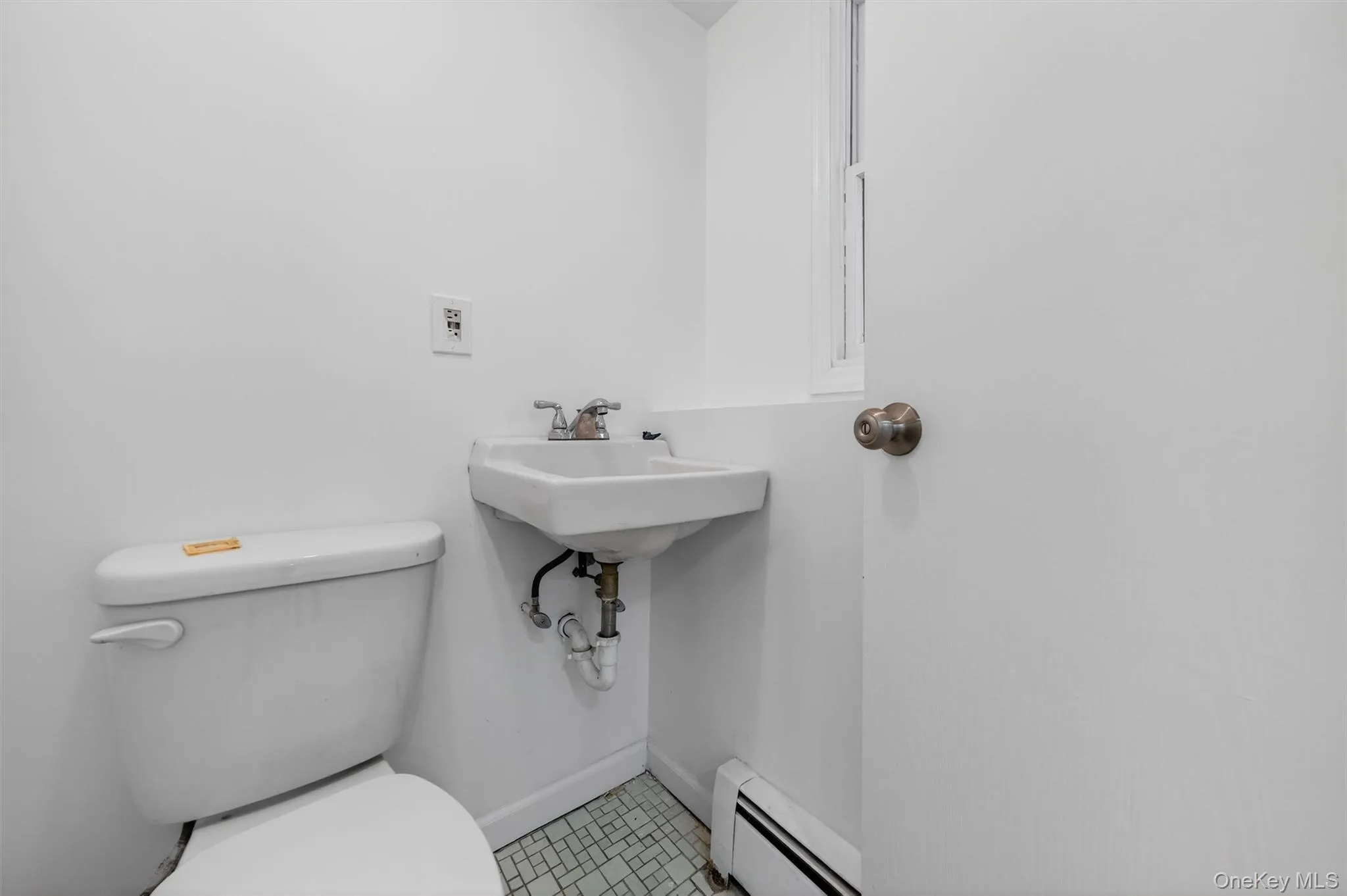 Half bathroom featuring a baseboard radiator and light tile patterned flooring Half bathroom featuring a baseboard radiator and light tile patterned flooring