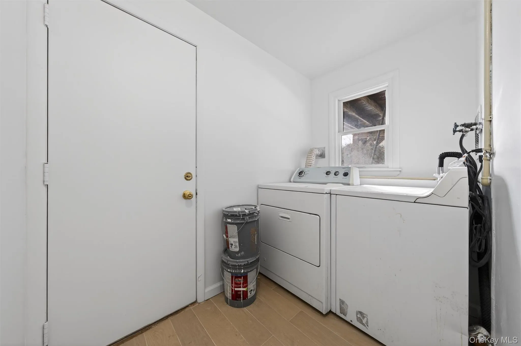 Laundry room featuring light wood-style floors and washing machine and dryer Laundry room featuring light wood-style floors and washing machine and dryer