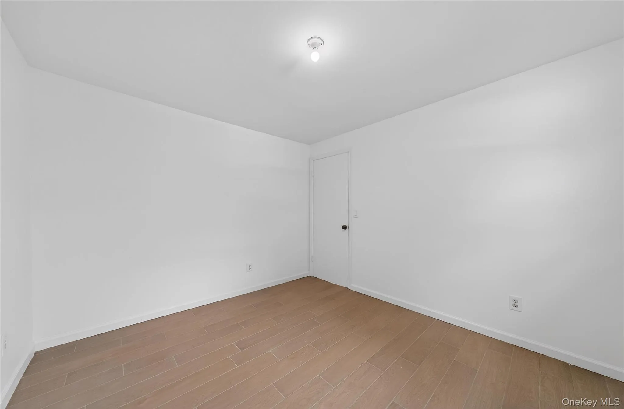 Spare room with light wood finished floors and baseboards Spare room with light wood finished floors and baseboards