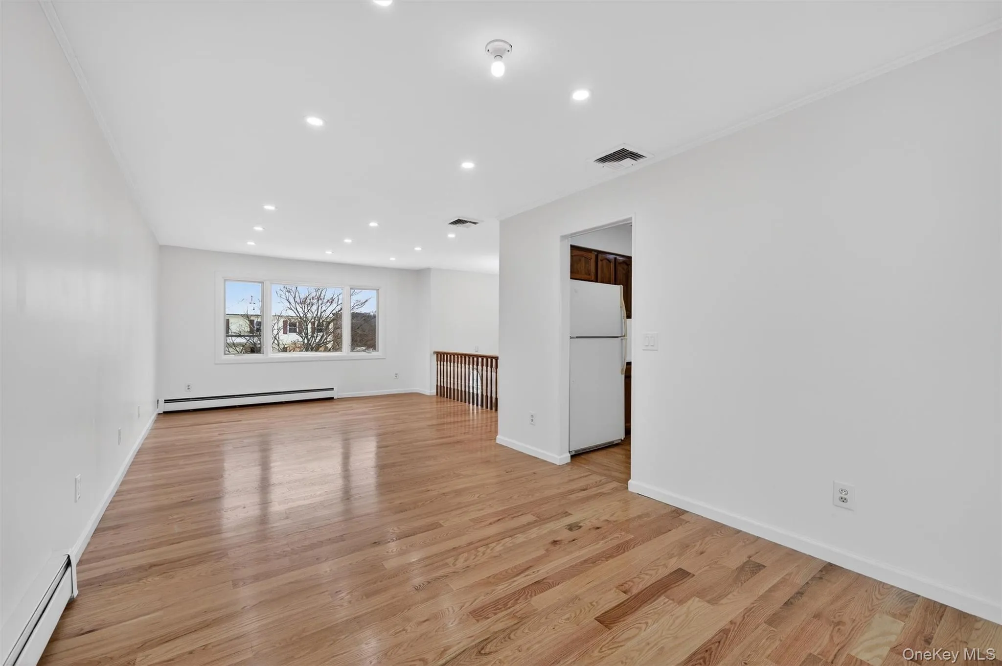 Unfurnished room featuring a baseboard radiator, recessed lighting, and light wood finished floors Unfurnished room featuring a baseboard radiator, recessed lighting, and light wood finished floors