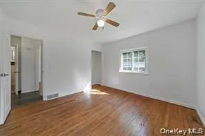 Spare room featuring wood finished floors and a ceiling fan Spare room featuring wood finished floors and a ceiling fan