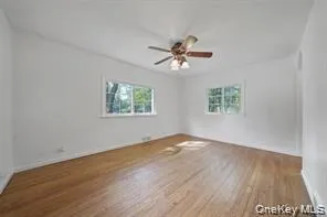 Unfurnished room with wood finished floors and baseboards Unfurnished room with wood finished floors and baseboards