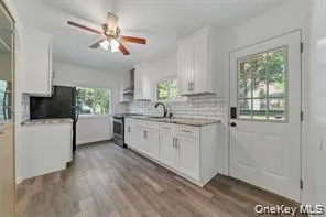 Kitchen featuring white cabinetry, light countertops, and light wood finished floors Kitchen featuring white cabinetry, light countertops, and light wood finished floors