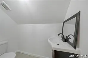 Bathroom featuring vaulted ceiling and vanity Bathroom featuring vaulted ceiling and vanity