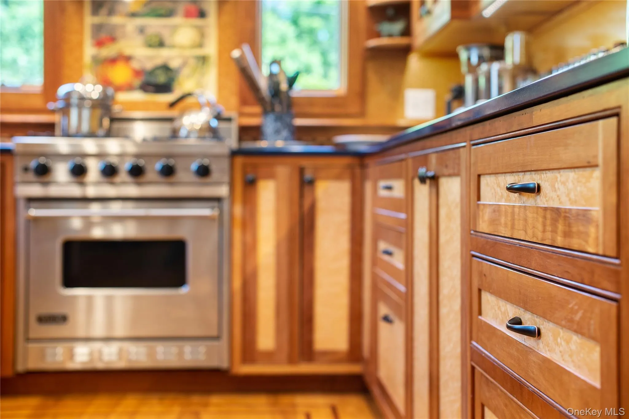 Kitchen featuring brown cabinets, high end stainless steel range oven, and open shelves Kitchen featuring brown cabinets, high end stainless steel range oven, and open shelves