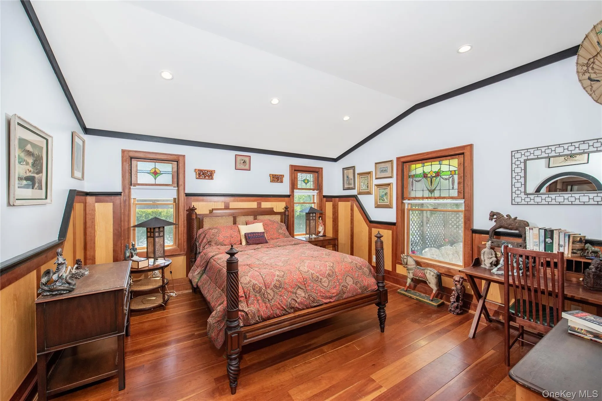 Bedroom featuring a wainscoted wall, recessed lighting, hardwood / wood-style flooring, lofted ceiling, and ornamental molding Bedroom featuring a wainscoted wall, recessed lighting, hardwood / wood-style flooring, lofted ceiling, and ornamental molding