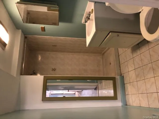 Full bath featuring a stall shower, vanity, and light tile patterned flooring Full bath featuring a stall shower, vanity, and light tile patterned flooring
