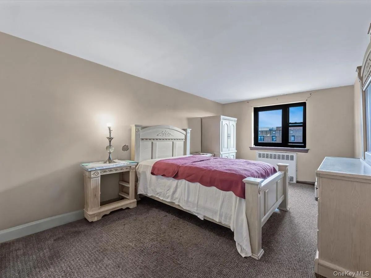 Bedroom featuring radiator heating unit and carpet Bedroom featuring radiator heating unit and carpet