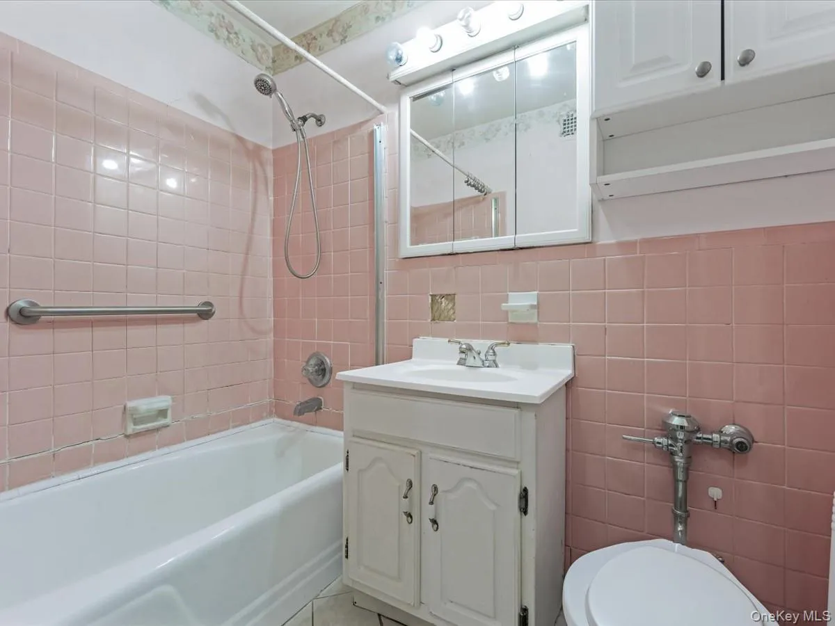 Bathroom featuring vanity, tile walls, and bathtub / shower combination Bathroom featuring vanity, tile walls, and bathtub / shower combination