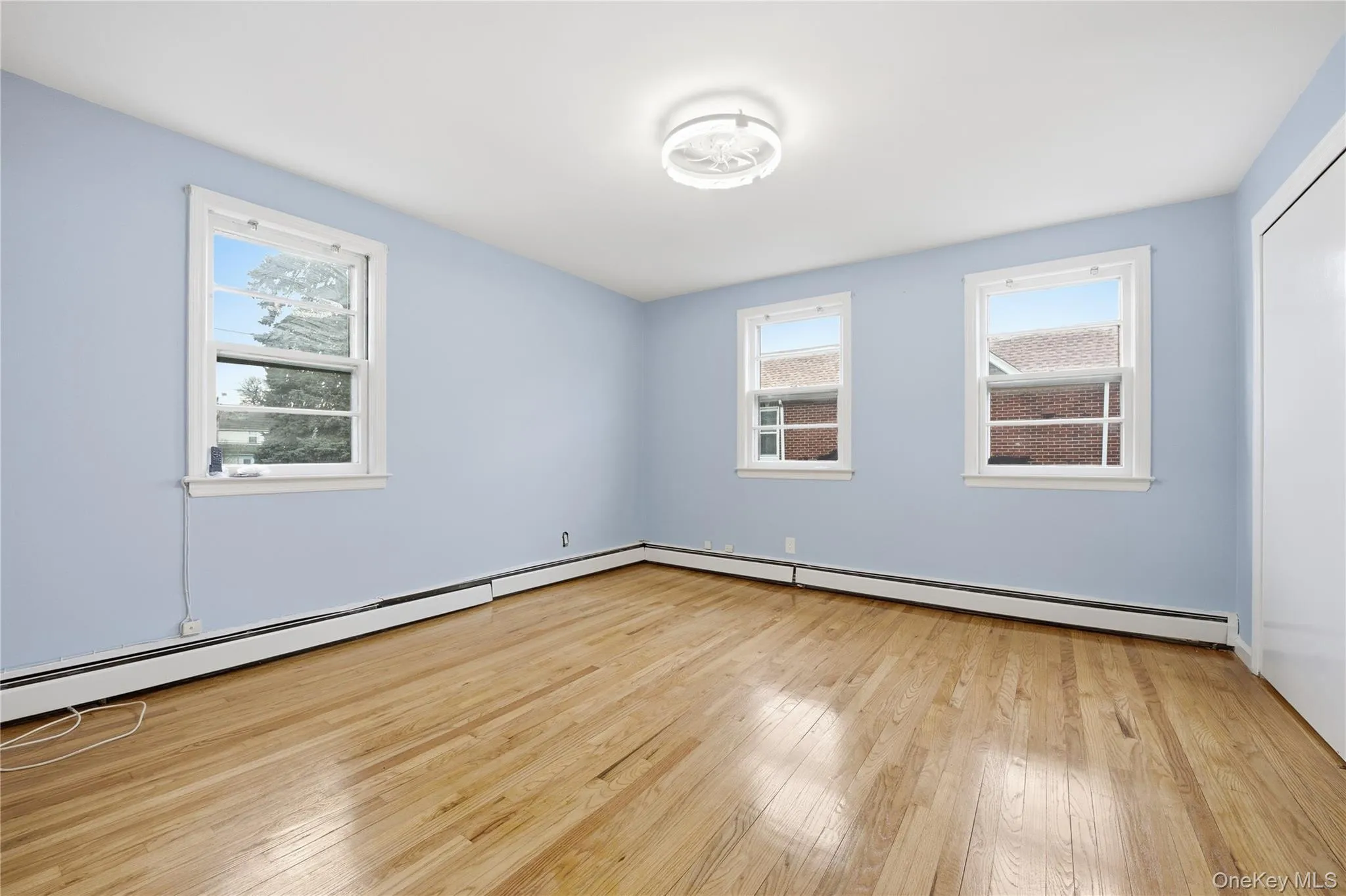 Spare room with a baseboard radiator and light wood-style floors Spare room with a baseboard radiator and light wood-style floors