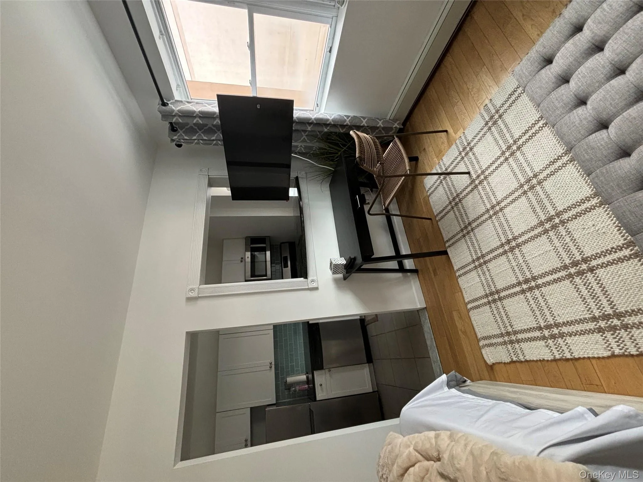 Bedroom with light wood finished floors and refrigerator Bedroom with light wood finished floors and refrigerator