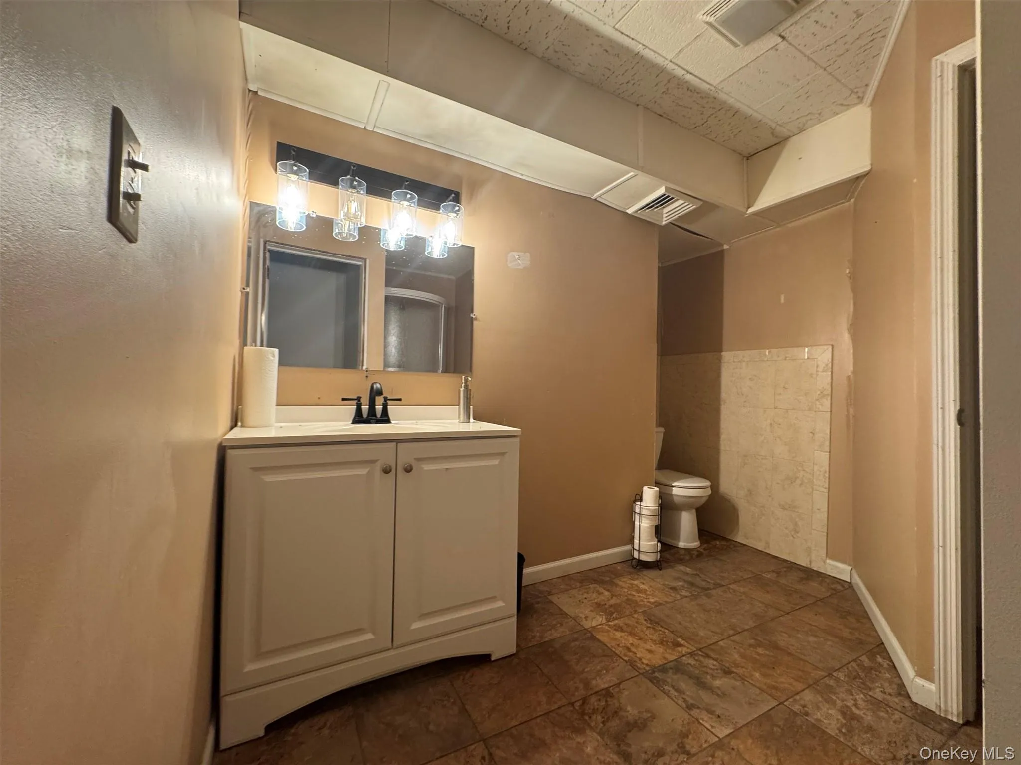 Bathroom featuring vanity and stone finish flooring Bathroom featuring vanity and stone finish flooring