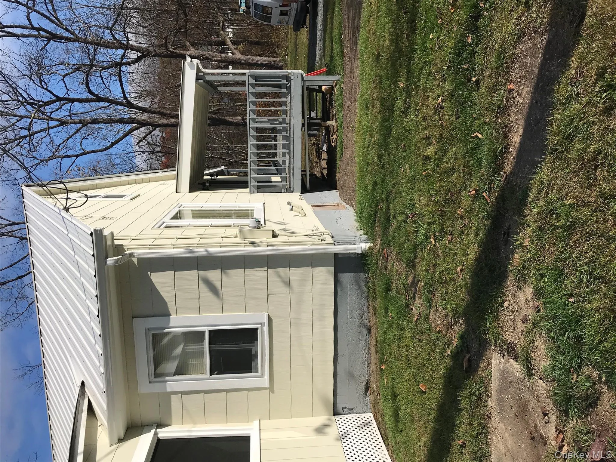 View of side of property with a lawn and a metal roof View of side of property with a lawn and a metal roof