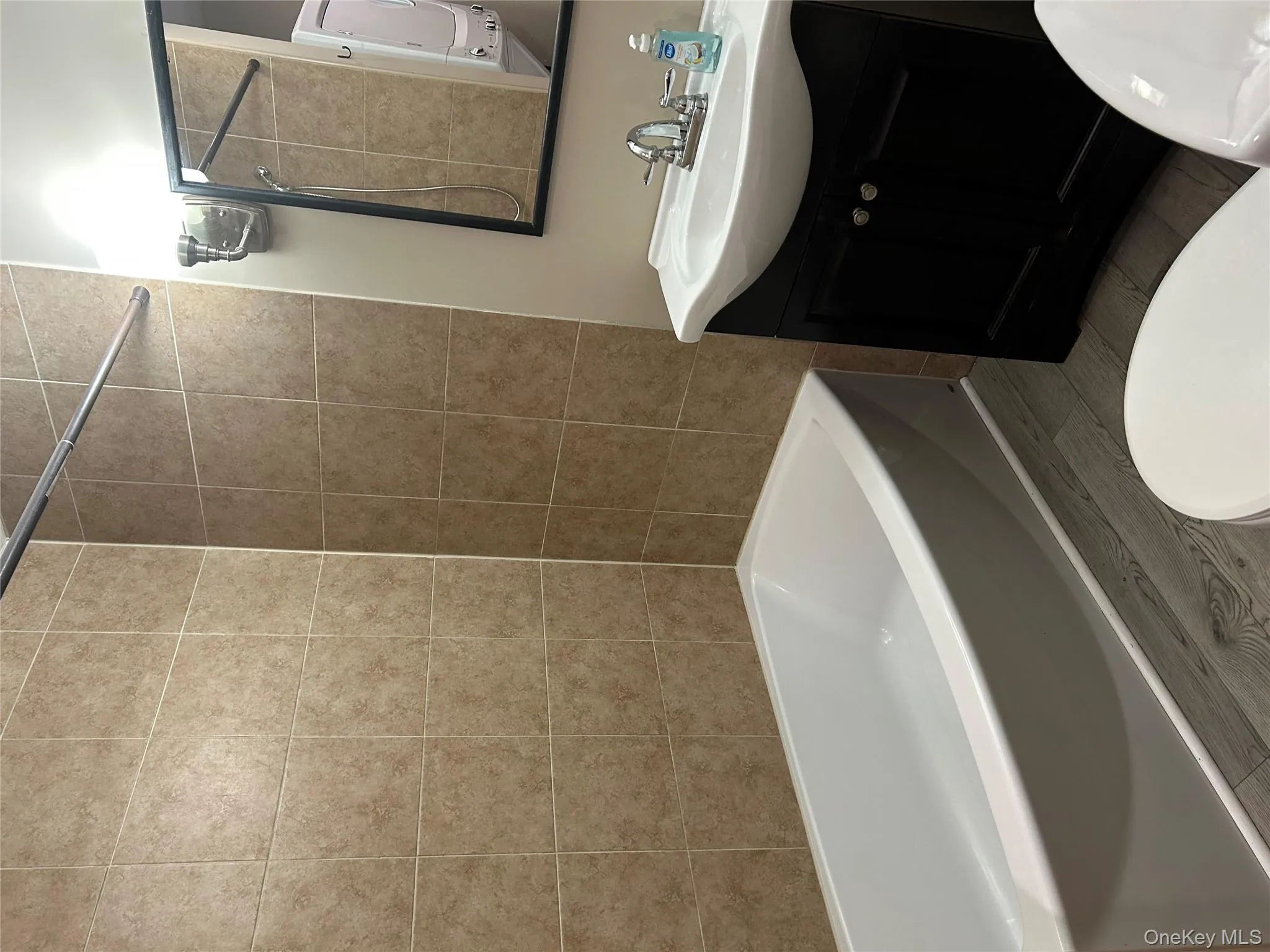 Bathroom featuring shower / bathtub combination, wood finish floors, and vanity Bathroom featuring shower / bathtub combination, wood finish floors, and vanity