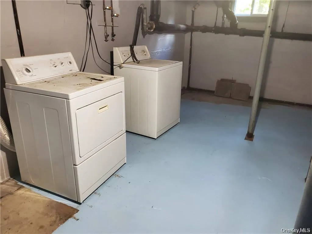 Laundry area with concrete flooring and washer and clothes dryer Laundry area with concrete flooring and washer and clothes dryer