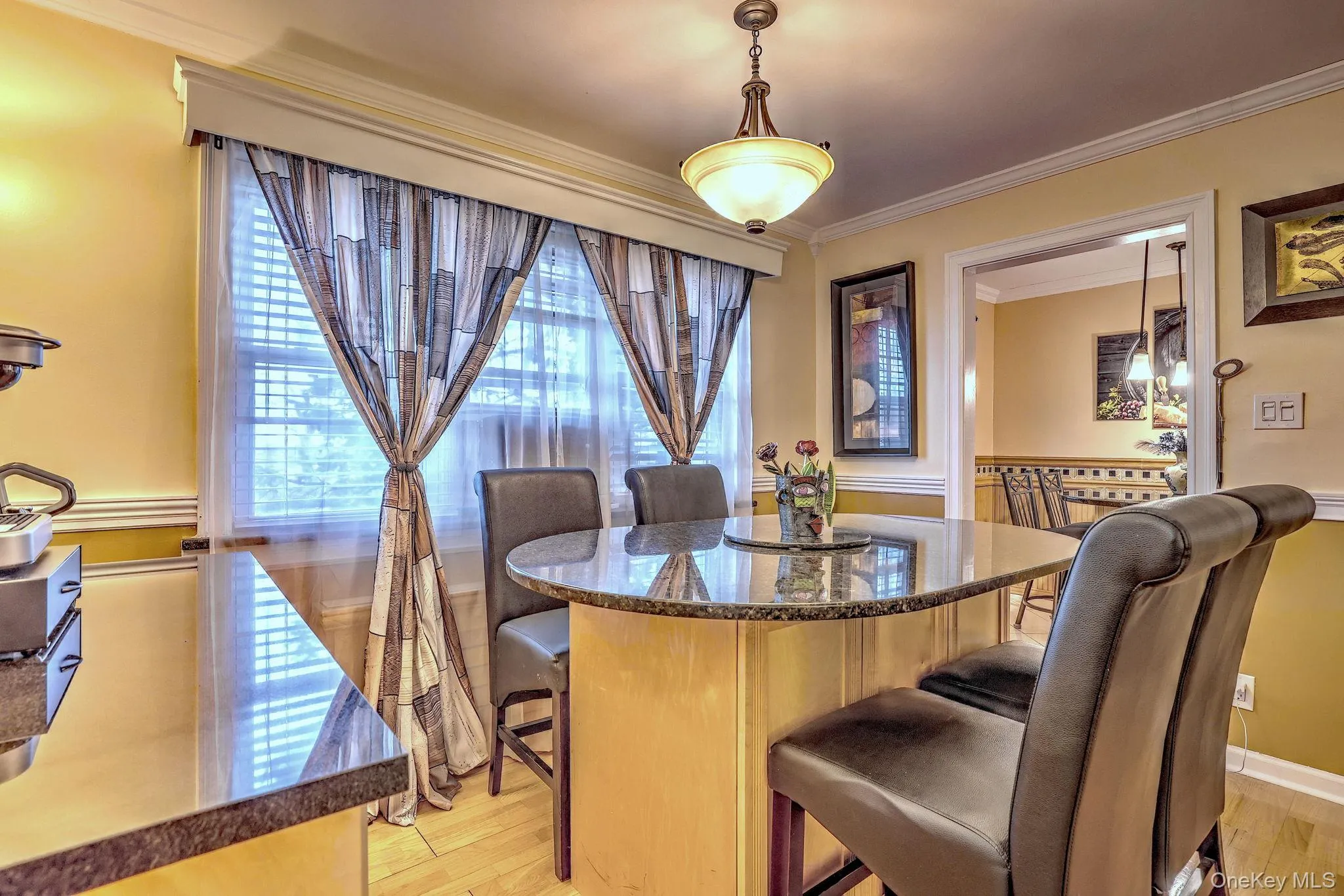 Dining room with ornamental molding and light wood-style flooring Dining room with ornamental molding and light wood-style flooring