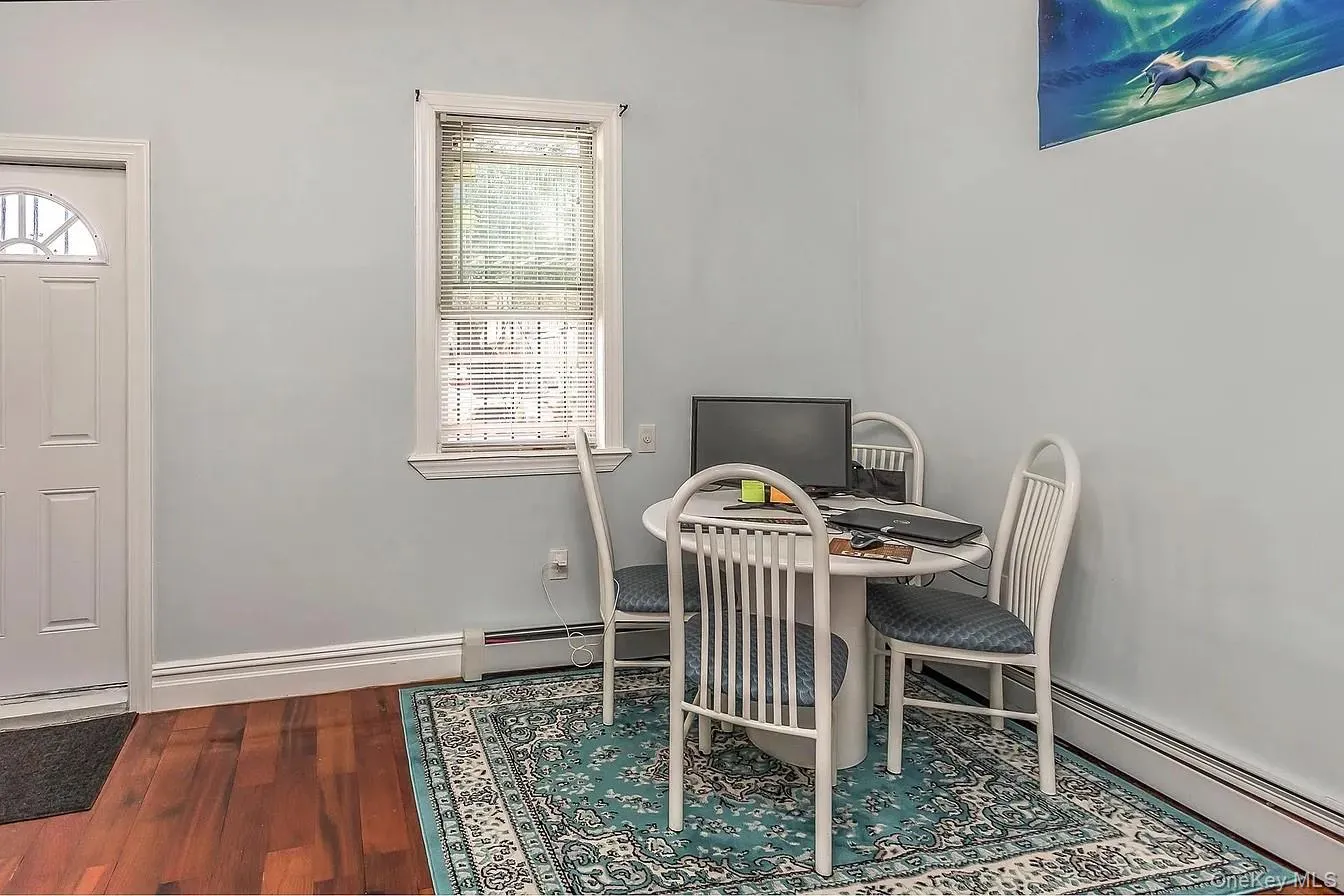 Dining area with dark wood-style floors, a baseboard heating unit, and a desk Dining area with dark wood-style floors, a baseboard heating unit, and a desk
