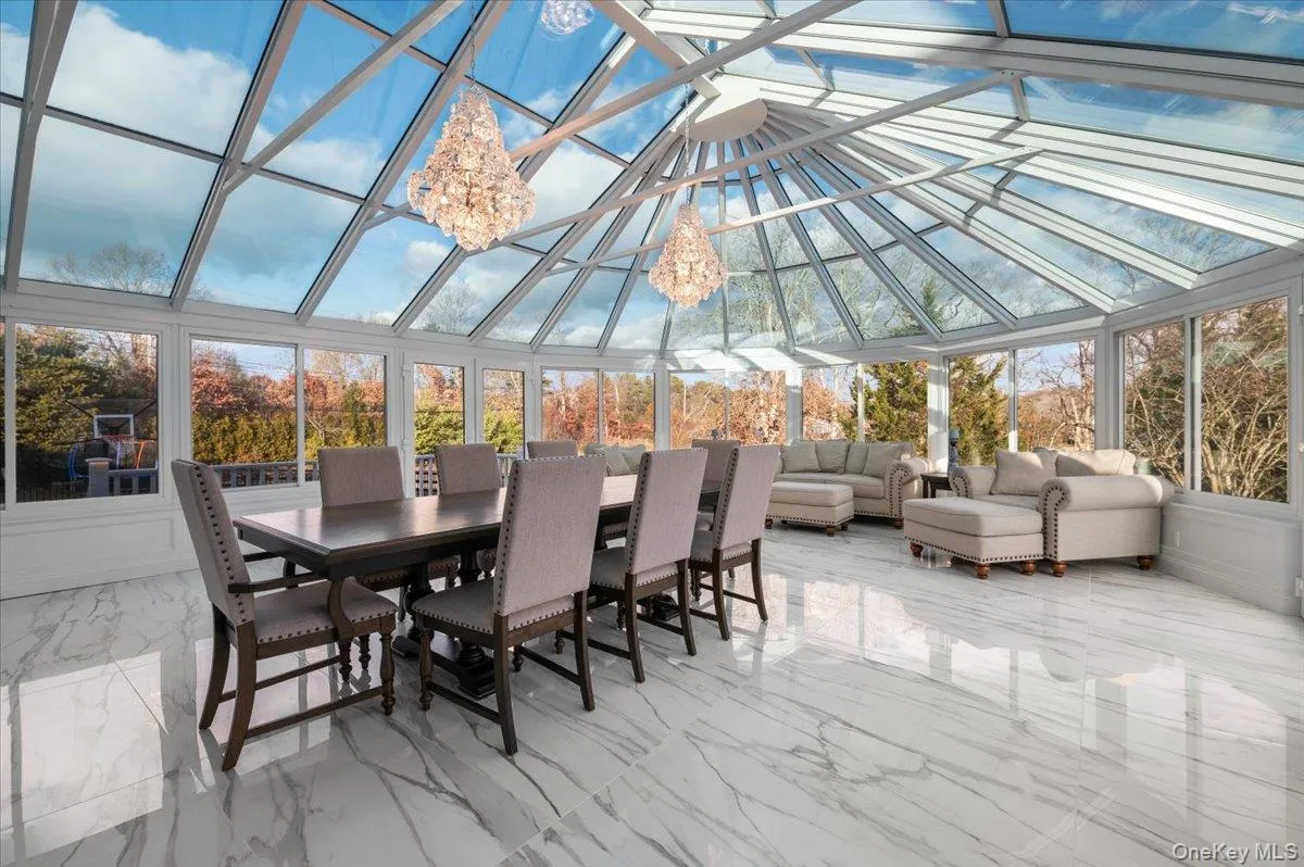 Sunroom / solarium with marble tiled floors, high vaulted ceiling, and a chandelier Sunroom / solarium with marble tiled floors, high vaulted ceiling, and a chandelier