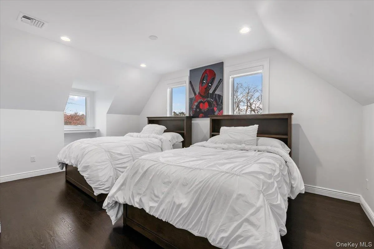 Bedroom with vaulted ceiling, dark wood-style floors, and recessed lighting Bedroom with vaulted ceiling, dark wood-style floors, and recessed lighting