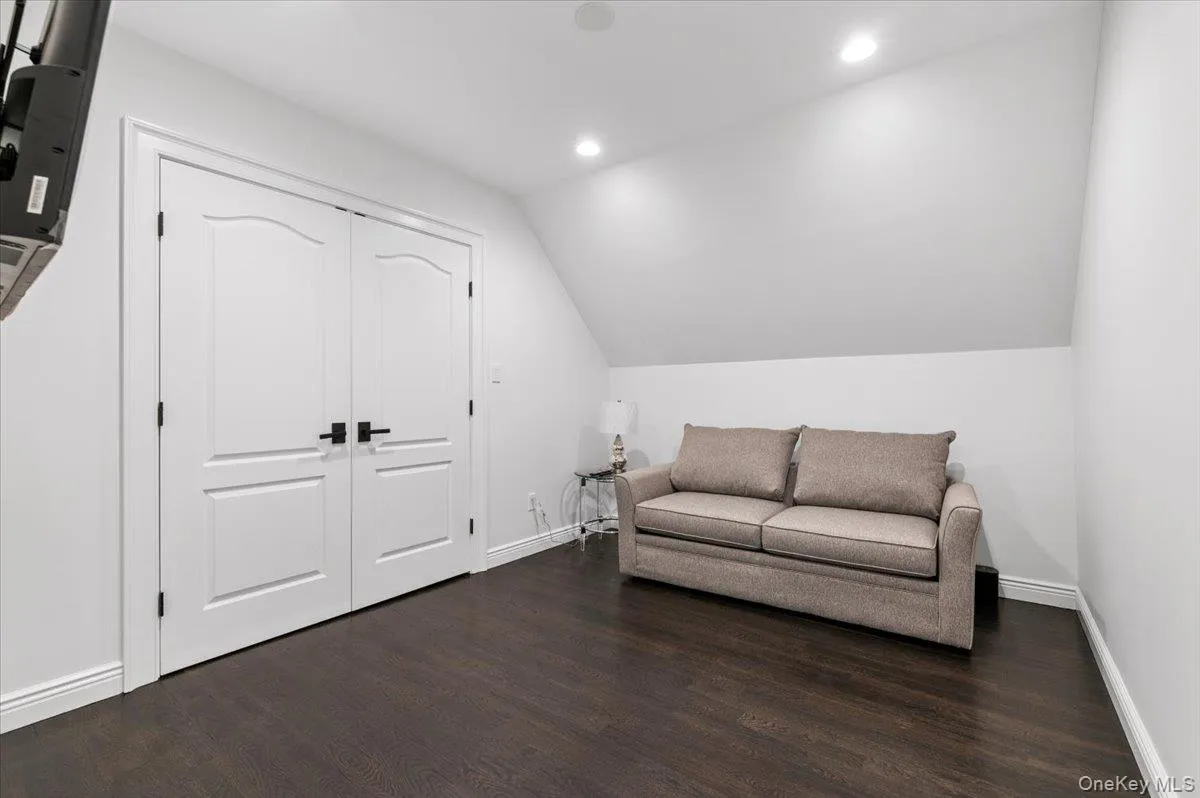Living area featuring recessed lighting, dark wood finished floors, and vaulted ceiling Living area featuring recessed lighting, dark wood finished floors, and vaulted ceiling