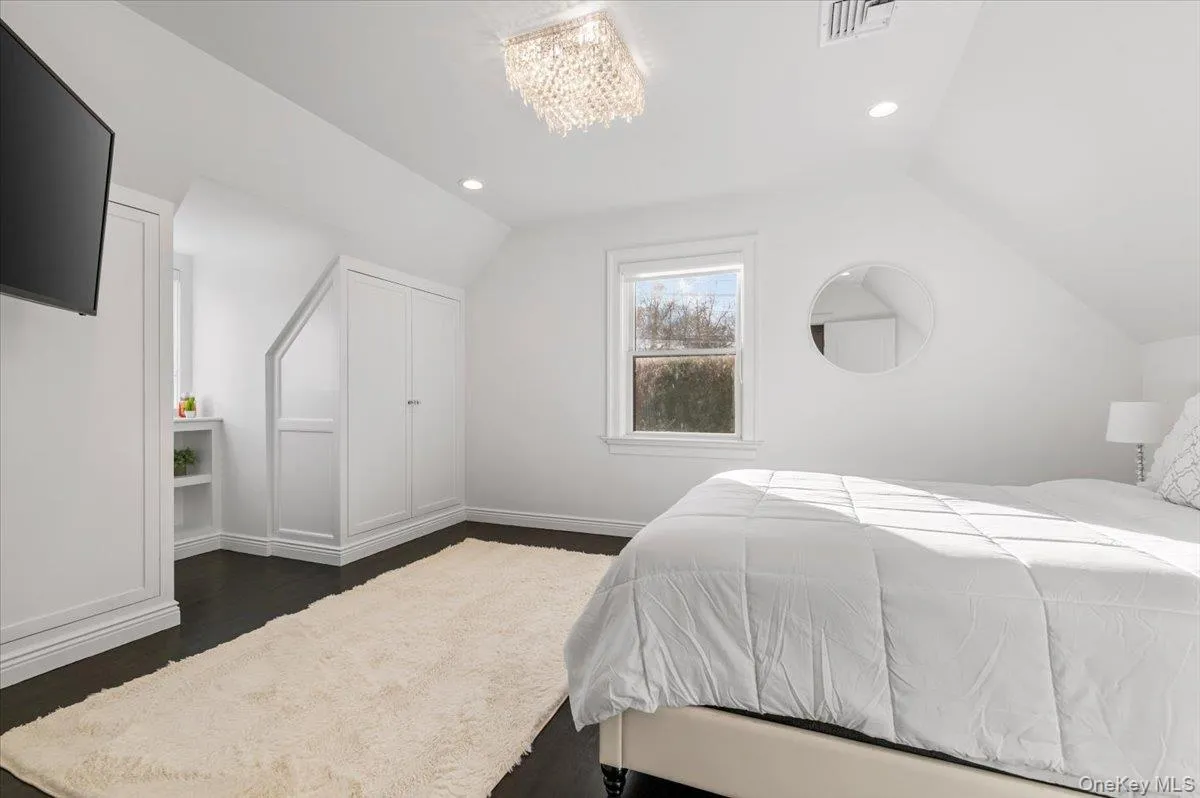 Bedroom with vaulted ceiling, recessed lighting, a chandelier, and dark wood finished floors Bedroom with vaulted ceiling, recessed lighting, a chandelier, and dark wood finished floors