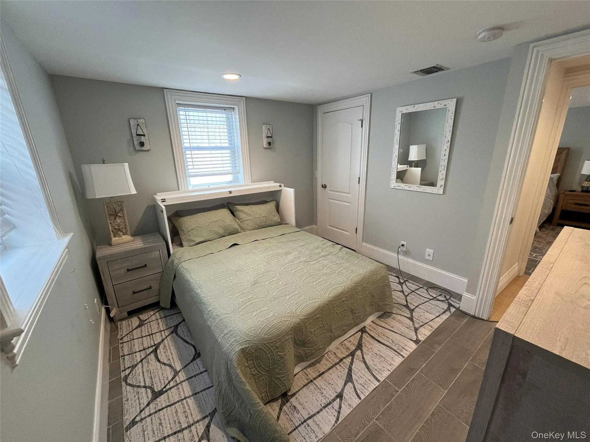 Bedroom with wood tiled floors and baseboards Bedroom with wood tiled floors and baseboards