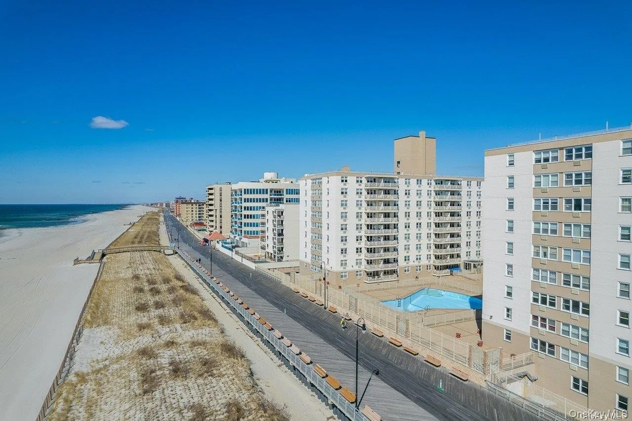 View of apartment building / complex with view of water and beach View of apartment building / complex with view of water and beach