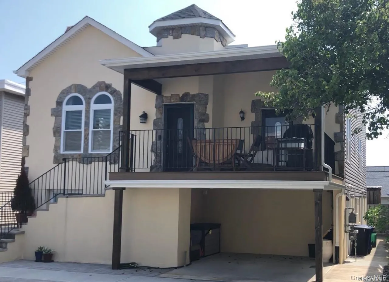View of front facade with stucco siding, stairway, and a balcony View of front facade with stucco siding, stairway, and a balcony