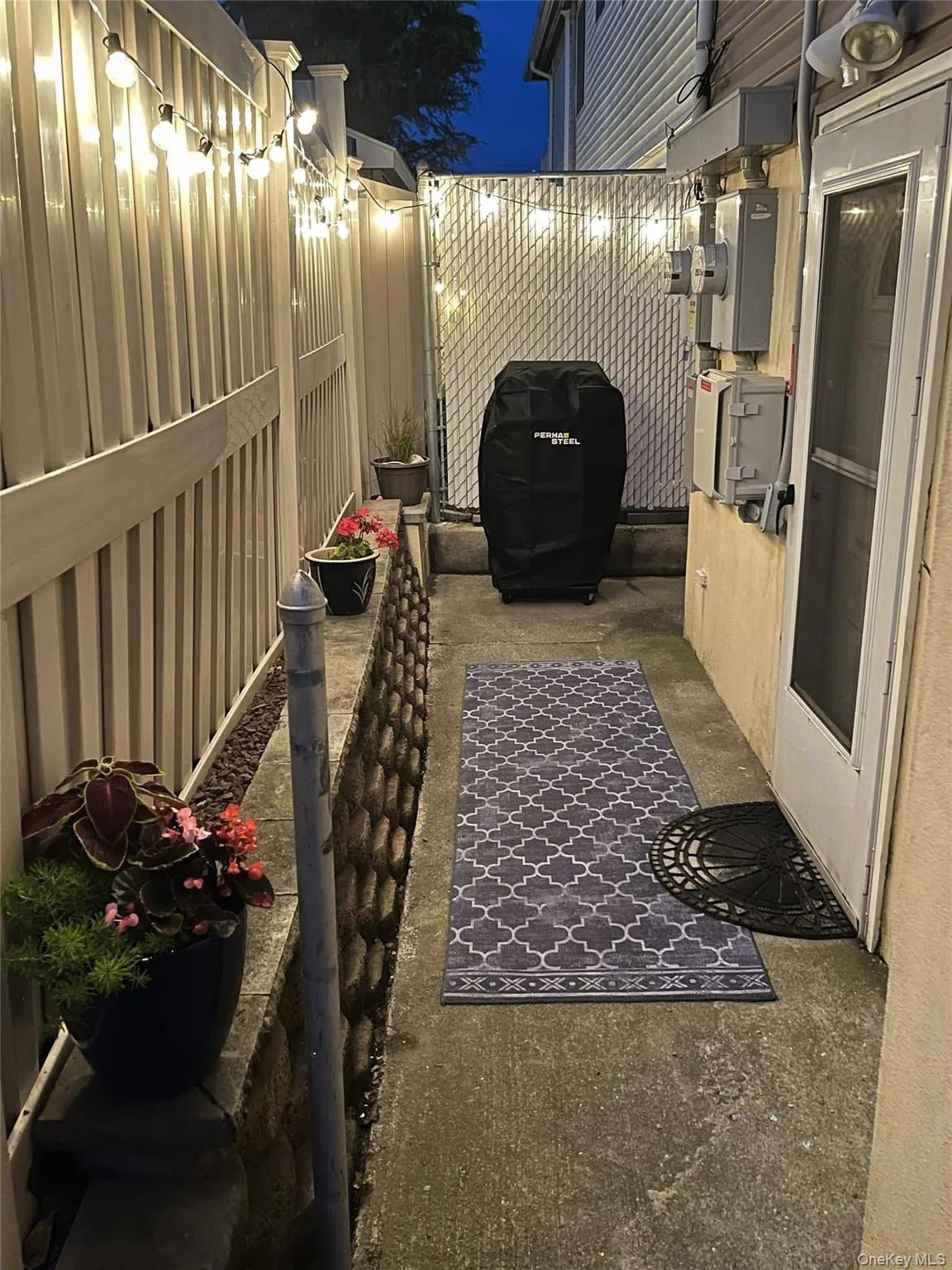 Patio at night with a fenced backyard and a patio Patio at night with a fenced backyard and a patio