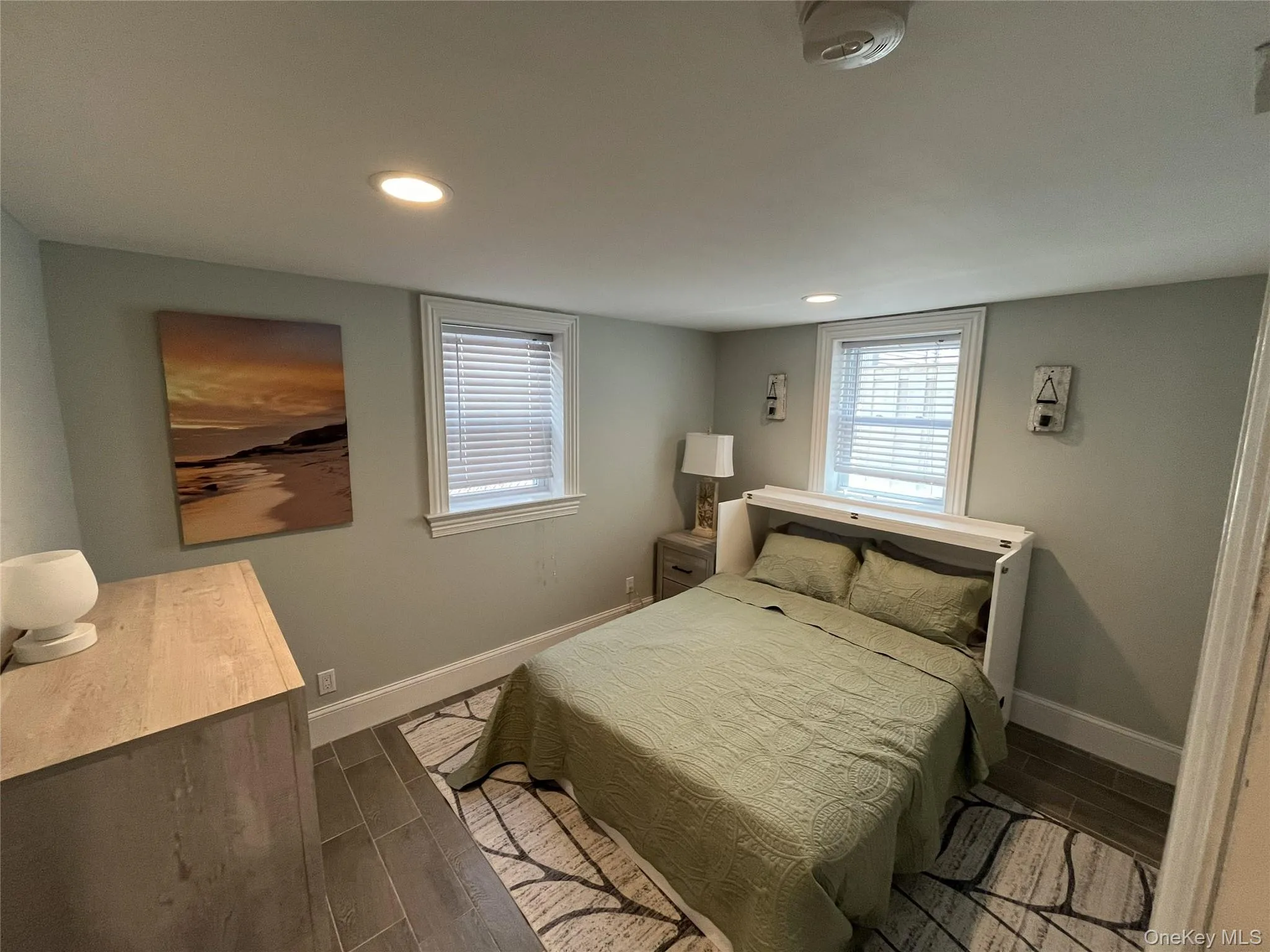 Bedroom with wood tiled floors, recessed lighting, and multiple windows Bedroom with wood tiled floors, recessed lighting, and multiple windows