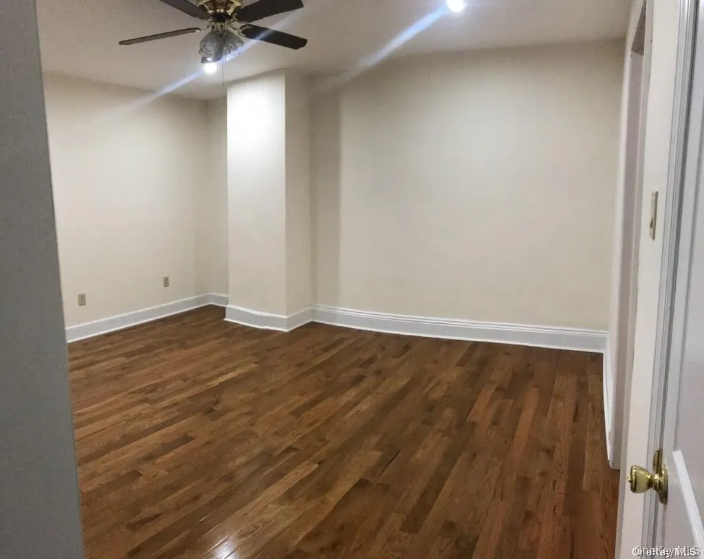 Spare room featuring dark wood finished floors and a ceiling fan Spare room featuring dark wood finished floors and a ceiling fan