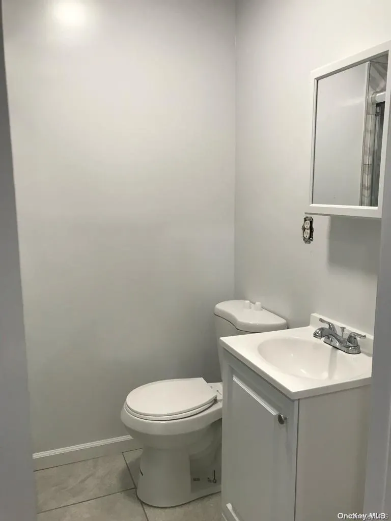 Half bathroom featuring vanity and light tile patterned floors Half bathroom featuring vanity and light tile patterned floors