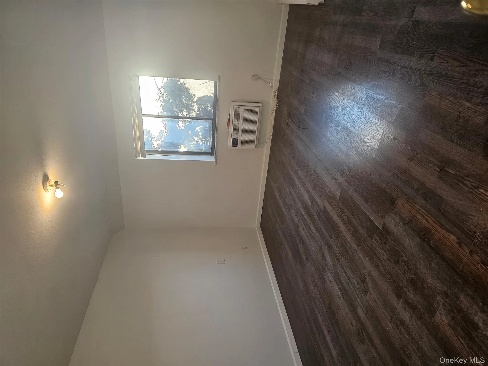 Unfurnished room featuring dark wood finished floors and baseboards Unfurnished room featuring dark wood finished floors and baseboards