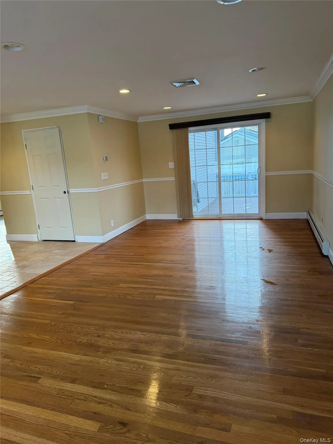 Spare room with light wood-type flooring, a baseboard radiator, and ornamental molding Spare room with light wood-type flooring, a baseboard radiator, and ornamental molding