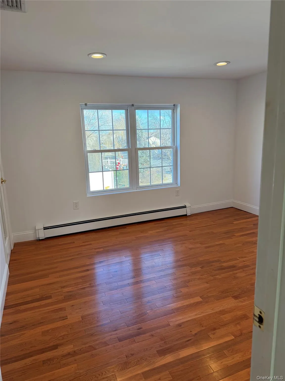 Unfurnished room featuring a baseboard radiator, light wood finished floors, and recessed lighting Unfurnished room featuring a baseboard radiator, light wood finished floors, and recessed lighting