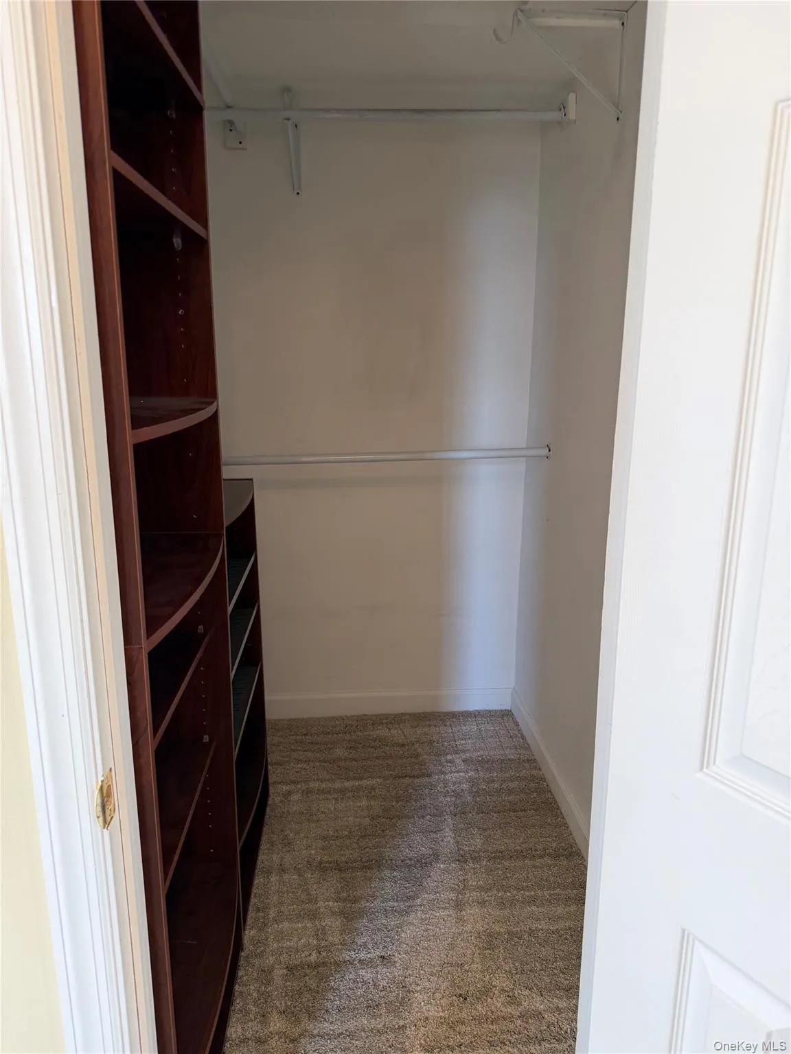 Walk in closet featuring light colored carpet Walk in closet featuring light colored carpet