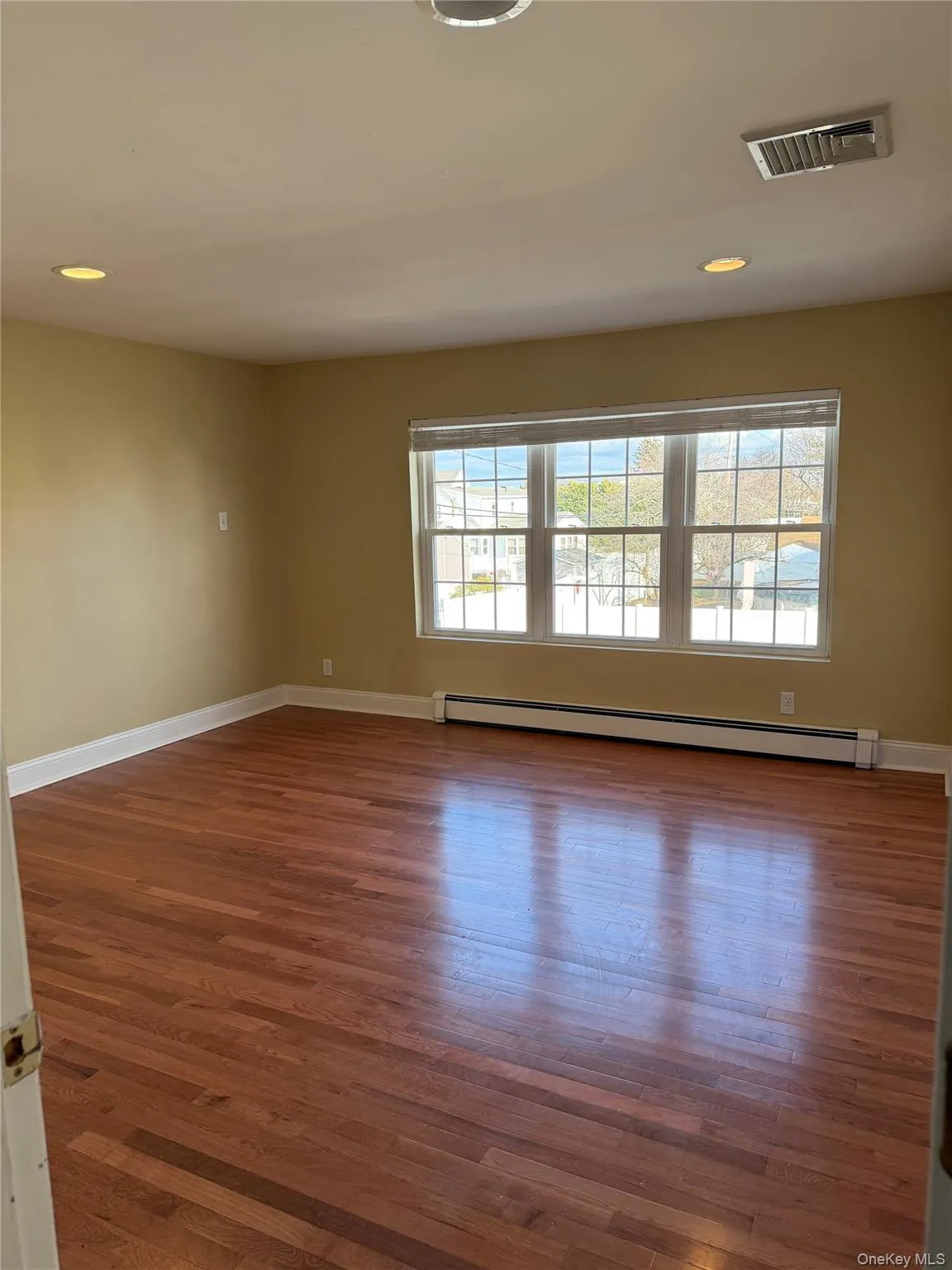 Spare room featuring recessed lighting, dark wood-type flooring, and baseboard heating Spare room featuring recessed lighting, dark wood-type flooring, and baseboard heating